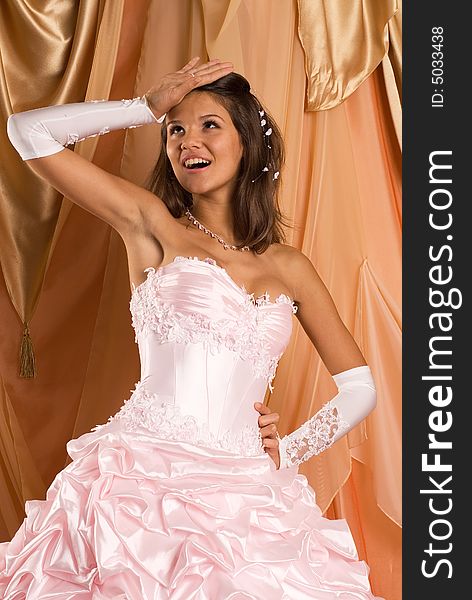 The bride in a wedding dress on beautiful background. The bride in a wedding dress on beautiful background