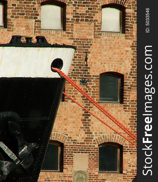 B&W fragment of moored ship on the background of bricked wall. B&W fragment of moored ship on the background of bricked wall.