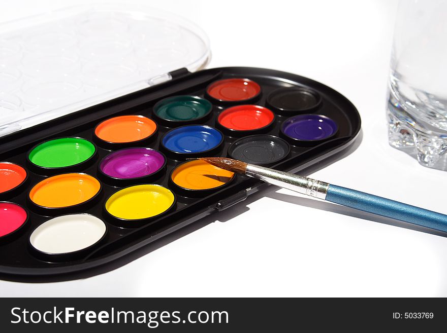 Palette of the watercolor paints and cysts on the white background