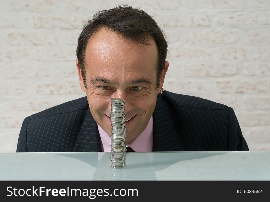 A shot of a businessman, with maniacal expression on his face, looking at a stack of quarters. A shot of a businessman, with maniacal expression on his face, looking at a stack of quarters.