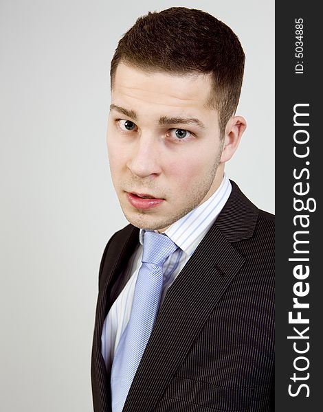 Portrait of young man in business clothes looking agressively at camera. Portrait of young man in business clothes looking agressively at camera