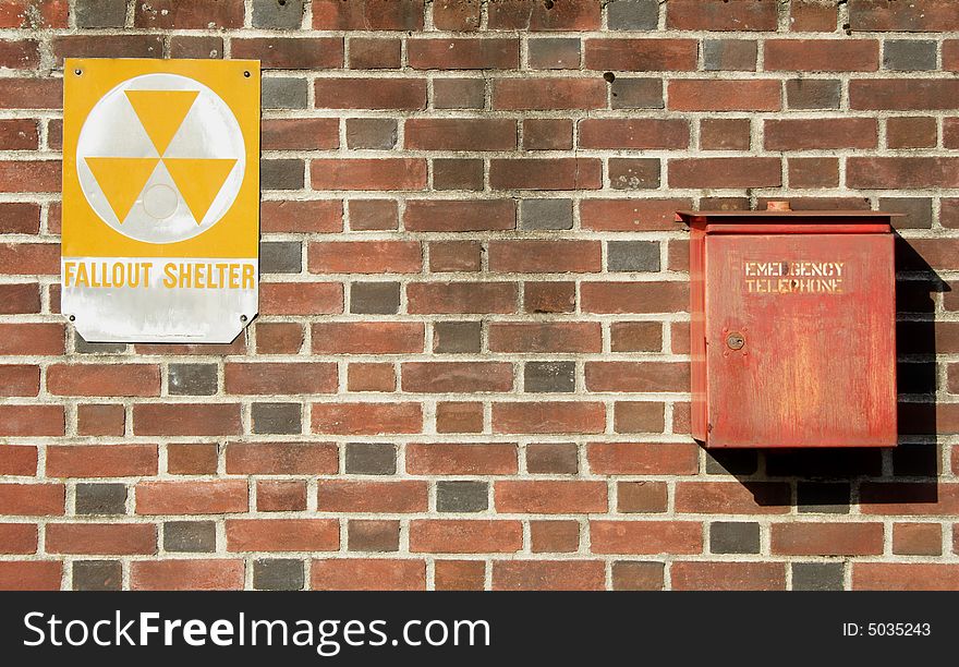 A fallout shelter sign and emergency telephone at the entrance to an underground shelter