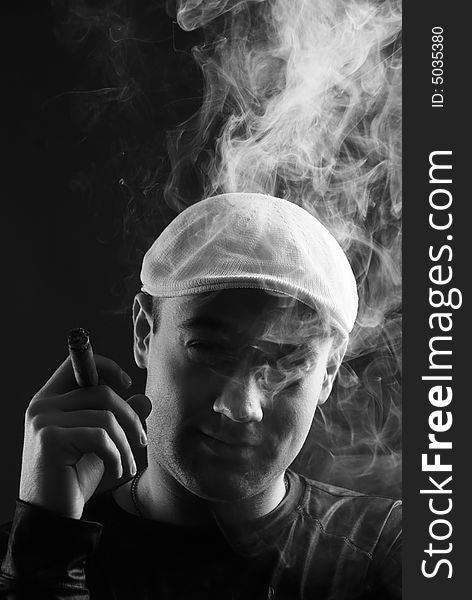 Man with cigare at black background