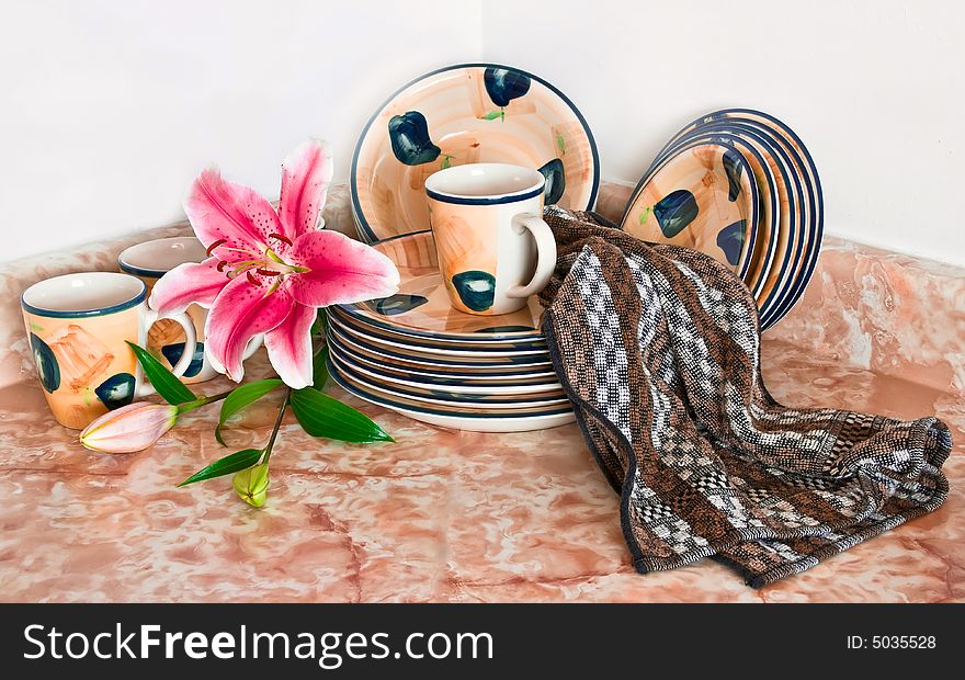 Clean dishes on the kitchen table with fresh flowers. Clean dishes on the kitchen table with fresh flowers