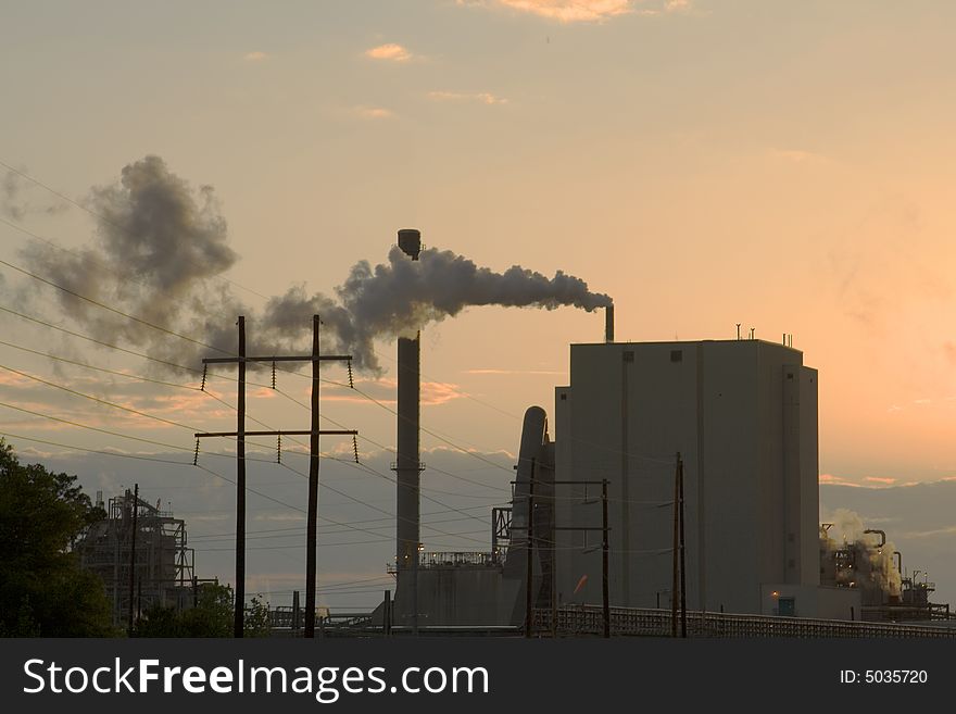 View of paper mill at sunset discharging into the air. View of paper mill at sunset discharging into the air