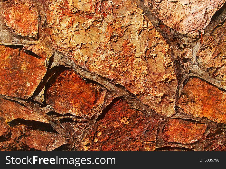 Old stone wall with rusty texture in earthy colors