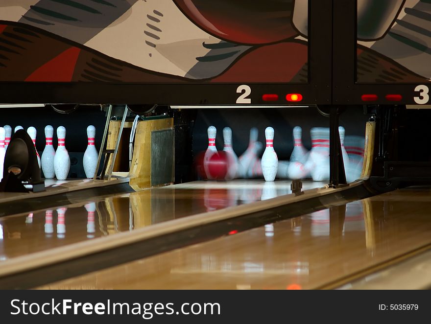 Bowling pins being knocked down at an alley by a a ball. Slow shutter speed. Bowling pins being knocked down at an alley by a a ball. Slow shutter speed.