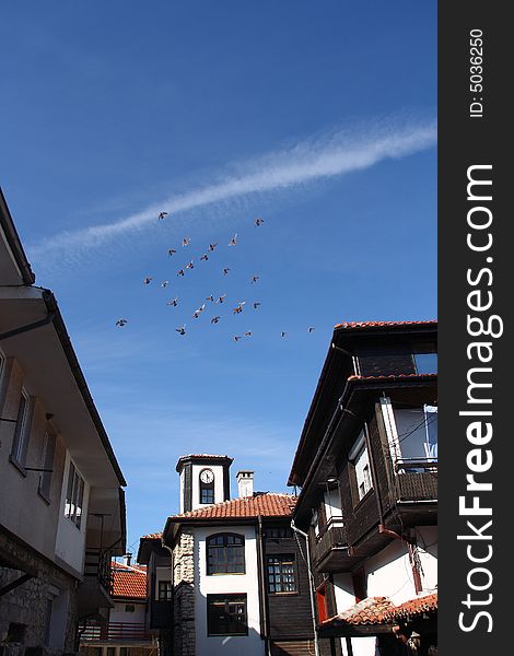 Pigeons flight over old town Nesebar in Bulgaria