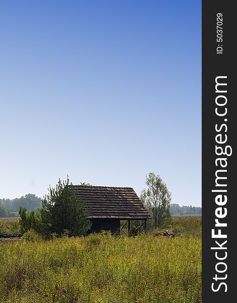 Old house on meadow with blue sky