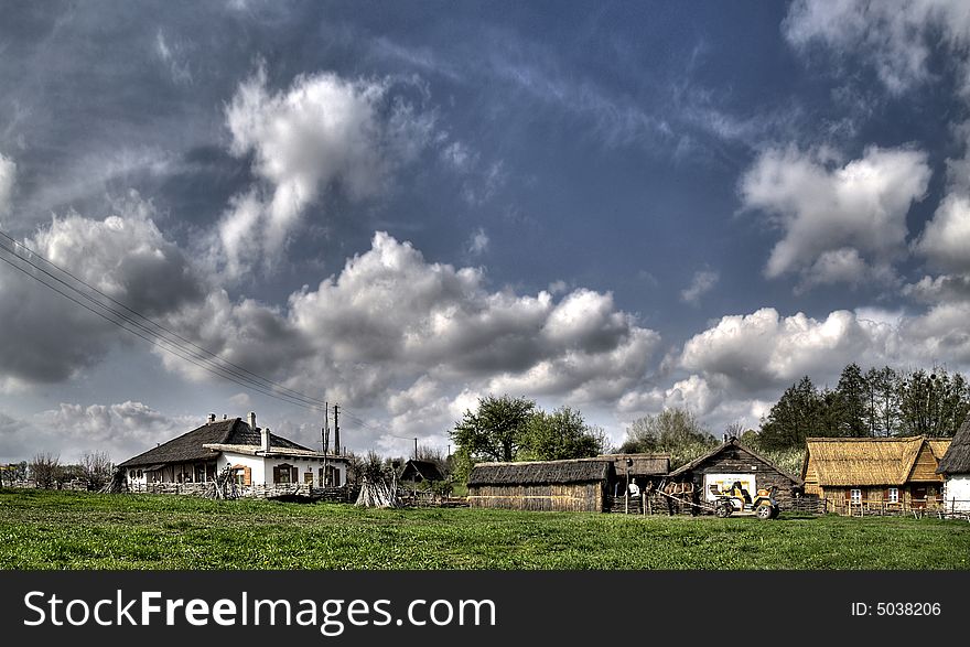 The photo captures the true image of a Ukrainian village. The sun is shining brightly, the chicken coop and cowshed framing an ancient house built of wood. In the foreground are green trees and blooming flowers, and in the background are yellow fields where the locals work in difficult weather. This picture vividly and colorfully conveys the atmosphere of coziness, comfort and simplicity of rural life in Ukraine. It would be suitable for use in any project related to tourism, nature or culture of the country. The photo captures the true image of a Ukrainian village. The sun is shining brightly, the chicken coop and cowshed framing an ancient house built of wood. In the foreground are green trees and blooming flowers, and in the background are yellow fields where the locals work in difficult weather. This picture vividly and colorfully conveys the atmosphere of coziness, comfort and simplicity of rural life in Ukraine. It would be suitable for use in any project related to tourism, nature or culture of the country.