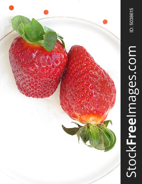 Two fresh strawberries on a plate