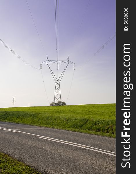 Silhouette of the electricity pylon with cables and the blue sky