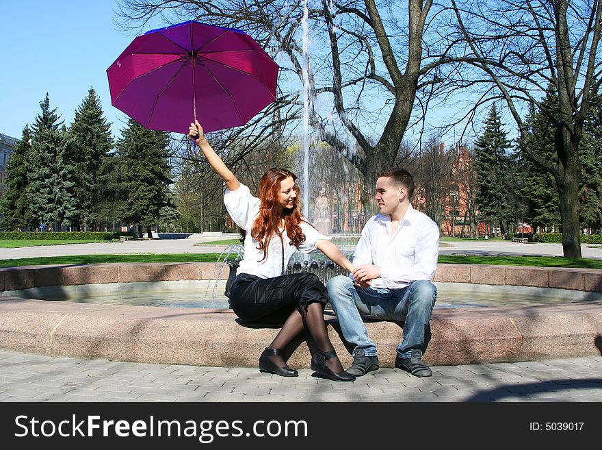 Young couple under violet umbrella