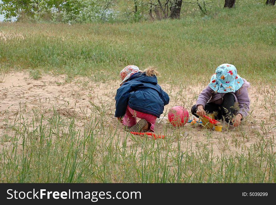 Two little girl playing with sand outdoors. Two little girl playing with sand outdoors