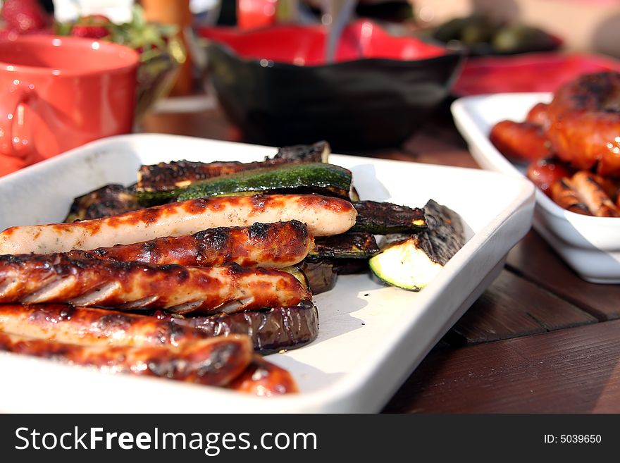 Grilled sausage and vegetables on table