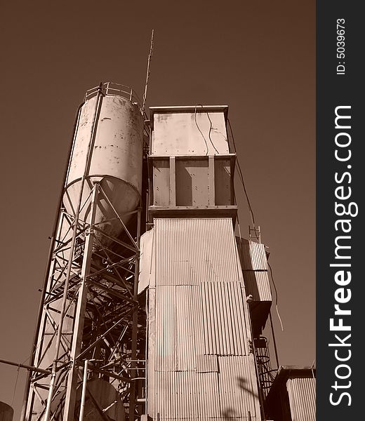 Cement factory in Berkeley California.  Sepia color.  Corrigated surface, run down, used.