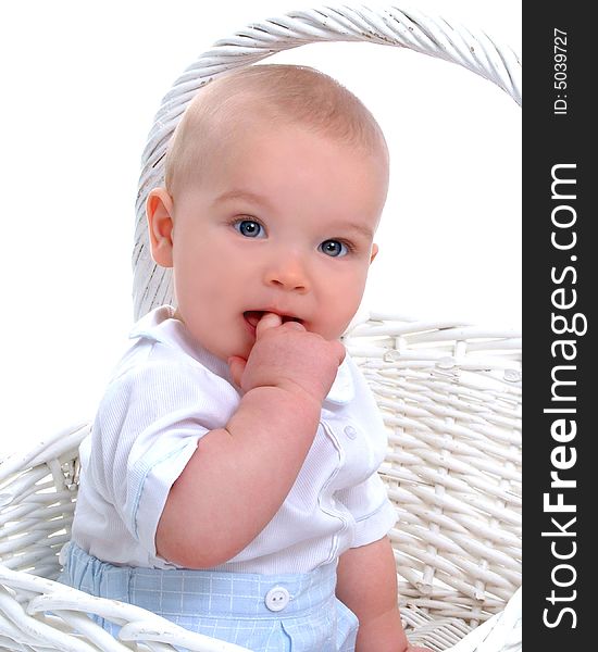 Closeup of baby boy in front of white background with hand in mouth