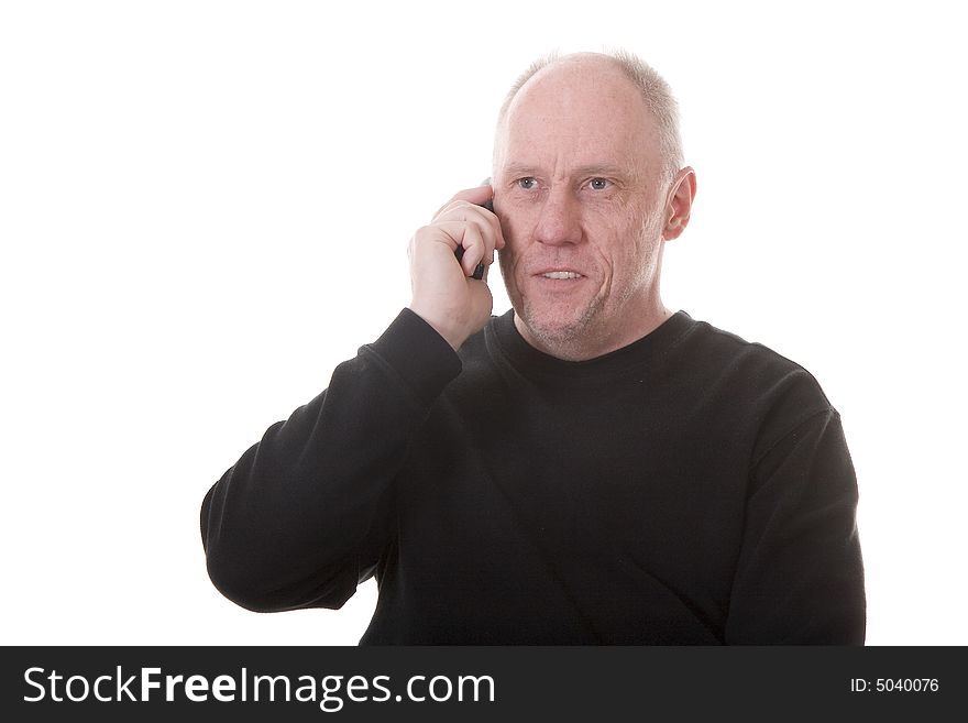 An older guy in a black shirt talking on a cell phone and smiling. An older guy in a black shirt talking on a cell phone and smiling