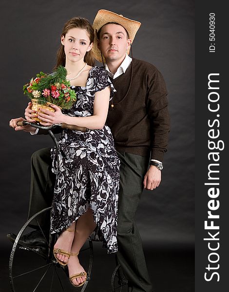Vintage couple on a bicycle over black background