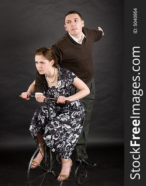 Vintage happy couple riding fast over dark background