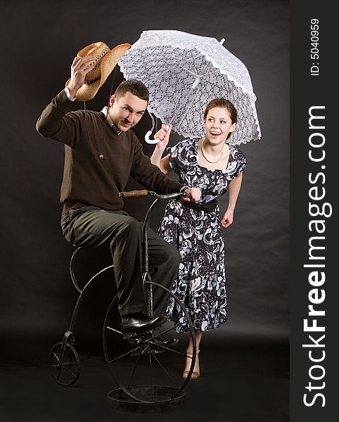 Vintage pair on a bicycle over dark background