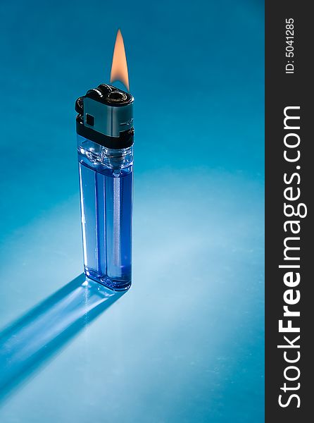 The inexpensive cigarette lighter on blue with back light. The inexpensive cigarette lighter on blue with back light