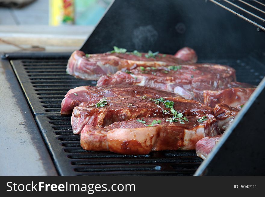 Big steaks with seasonings on barbecue grill. Big steaks with seasonings on barbecue grill