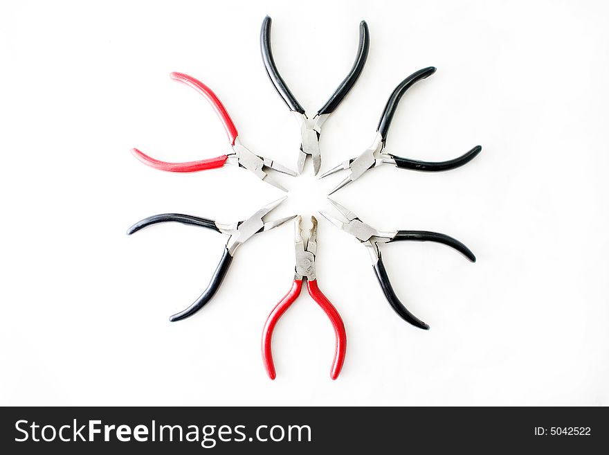 Set of black and red pliers arranged in a circular form. Set of black and red pliers arranged in a circular form