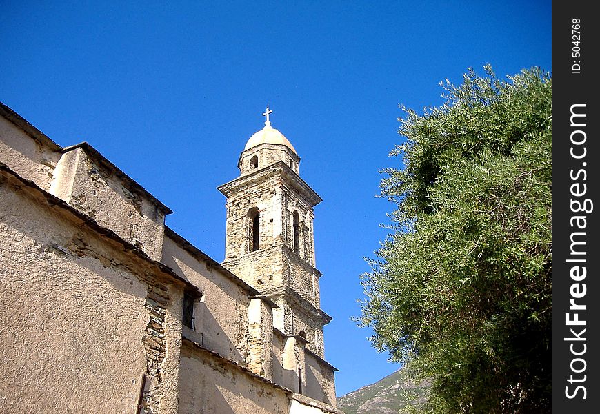 View of church bell tower in Farinole, a secluded mountain village in Cap Corse, France. View of church bell tower in Farinole, a secluded mountain village in Cap Corse, France.