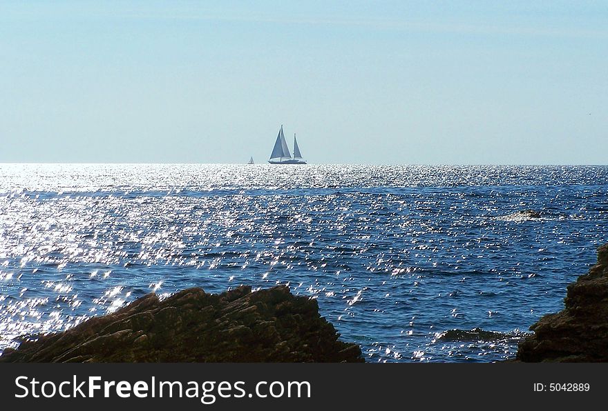 Sailboat at sunset in the Straits of Bonifacio, the wind-swept waterway that separates the coast of France from Italy.