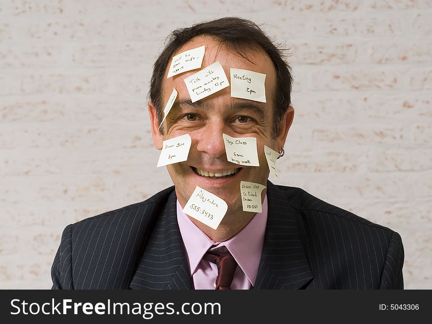 A shot of a business man's head covered in yellow stickynotes. A shot of a business man's head covered in yellow stickynotes.