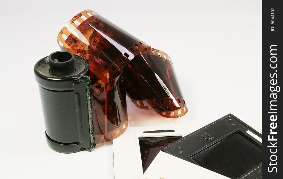 Film in the cartridge and slides in frameworks on a white background. Film in the cartridge and slides in frameworks on a white background.