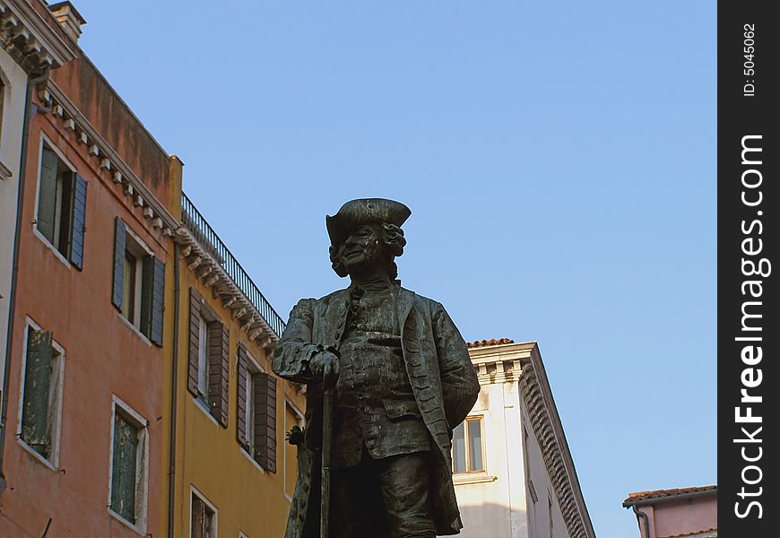 Venice (Italy) postcard: statue of a noble man against clear blue sky and colorful palace facades, with space for text (copyspace)