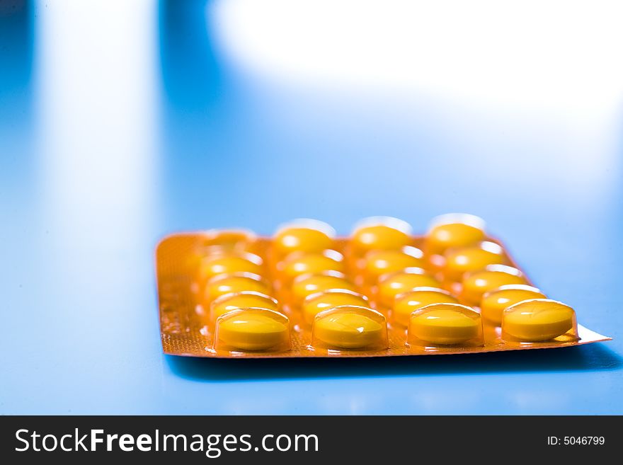 Pills on blue background; Shallow depth of field.
