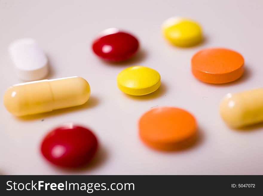 Pills on white background; Shallow depth of field.