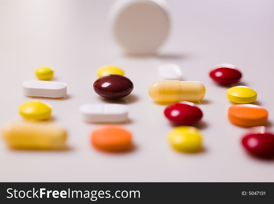 Pills on  white background; Shallow depth of field.