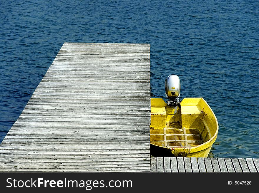 Yellow motorboat at jetty in blue lake. Yellow motorboat at jetty in blue lake