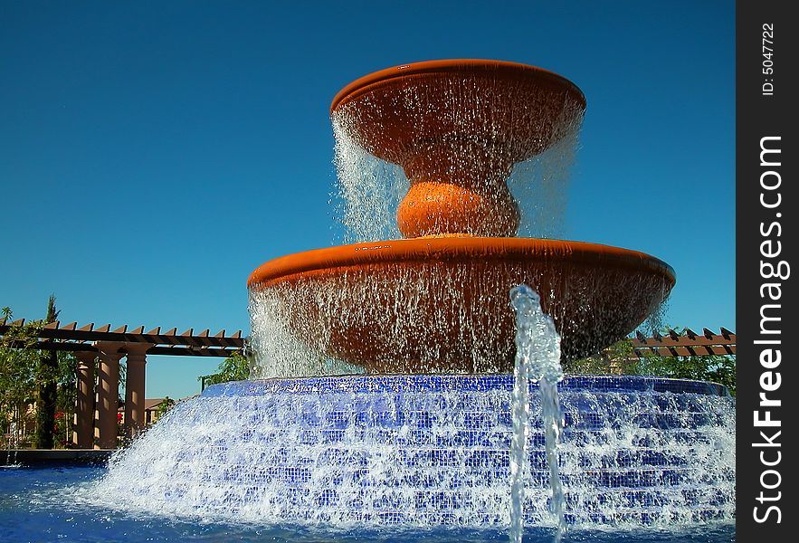 A large water fountain with cascading base surrounded by an arbor in master planned community. A large water fountain with cascading base surrounded by an arbor in master planned community.