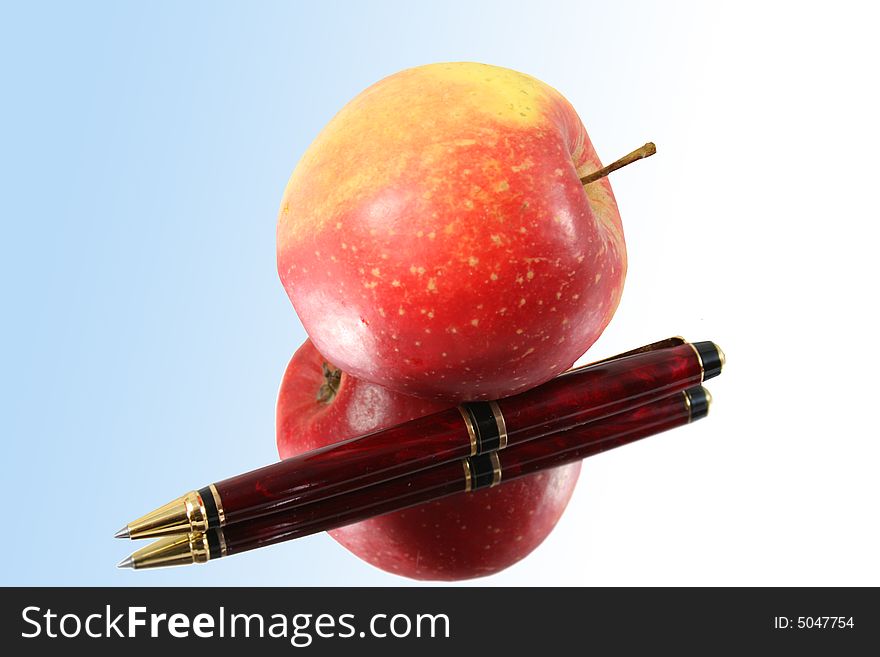 Pen and apple on blue background with reflection. Pen and apple on blue background with reflection