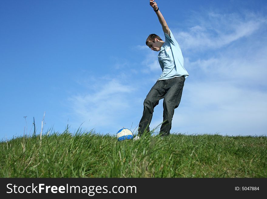 Young boy playing football on grass
