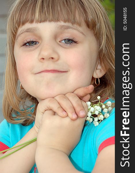 Little pretty girl with lilies on the background of white bricks. Little pretty girl with lilies on the background of white bricks