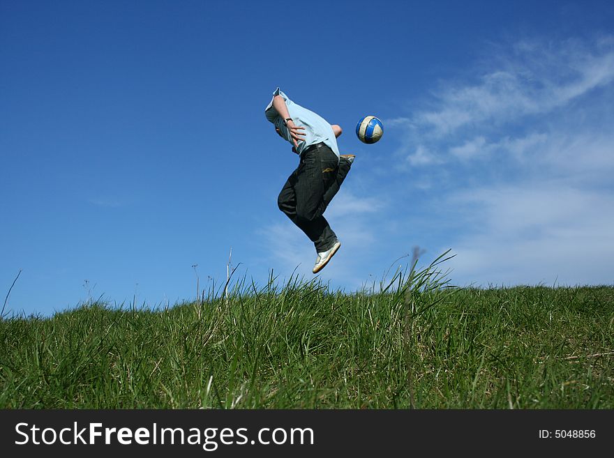 Young boy playing football on grass