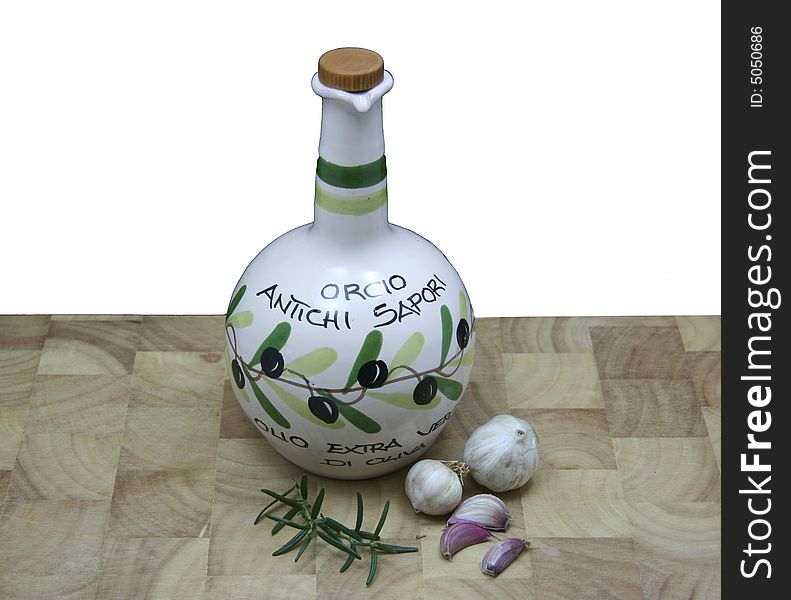 Spannish olive oil with fresh garlic and rosemary on chopping board. Spannish olive oil with fresh garlic and rosemary on chopping board