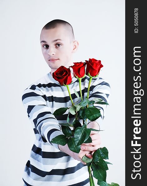 Young man with red roses at white background. Young man with red roses at white background