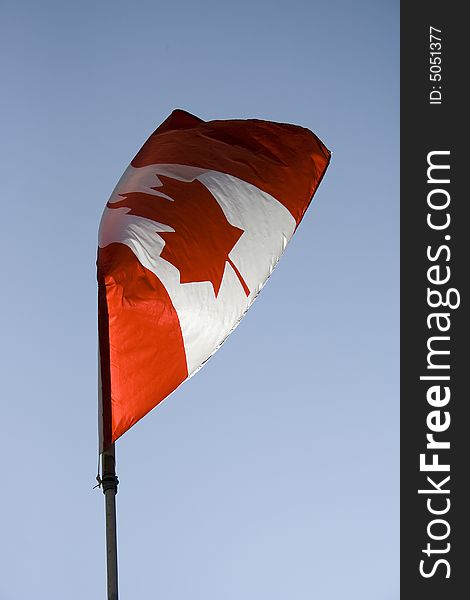 Canadian flag flying in a blue sky