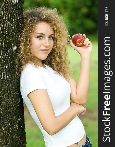 A young attractive woman holding an apple