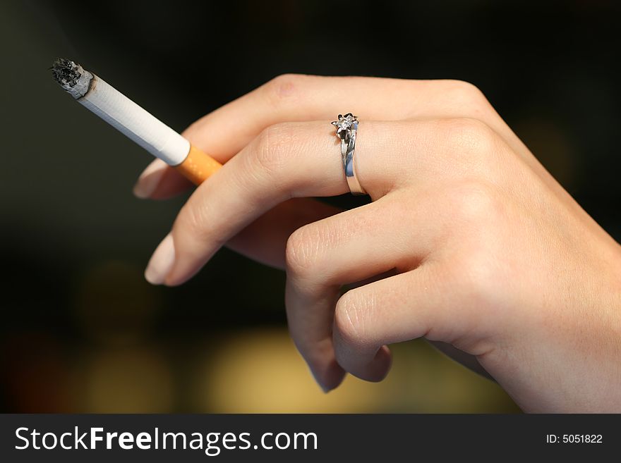 Young woman´s hand with burning cigarette. Young woman´s hand with burning cigarette