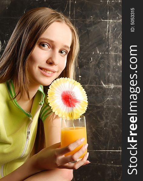 Beautiful teen girl holding an orange juise