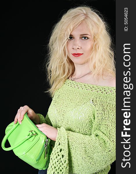 Natural blond with the green bag against the black background. Natural blond with the green bag against the black background