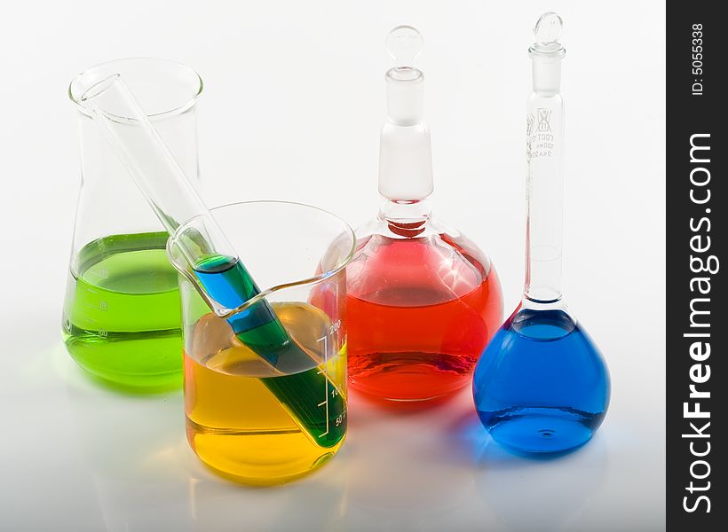 Various colorful flasks over white background